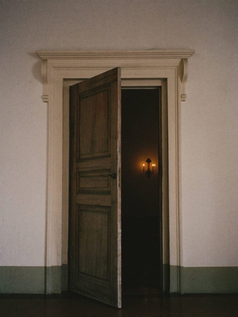 Placeholder — intended image: Monastery chapel door opening onto warm interior light, documentary close crop