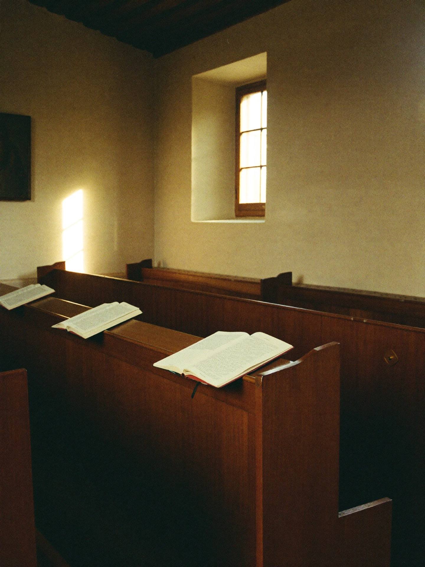Placeholder — intended image: Choir stalls and open liturgical books in warm chapel light, vertical composition